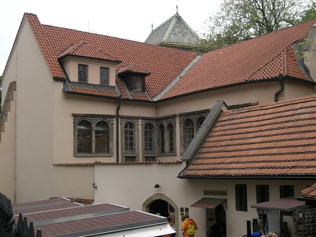 Exterior of the Pinkas Synagogue in Prague with its tiled roof and pale façade.